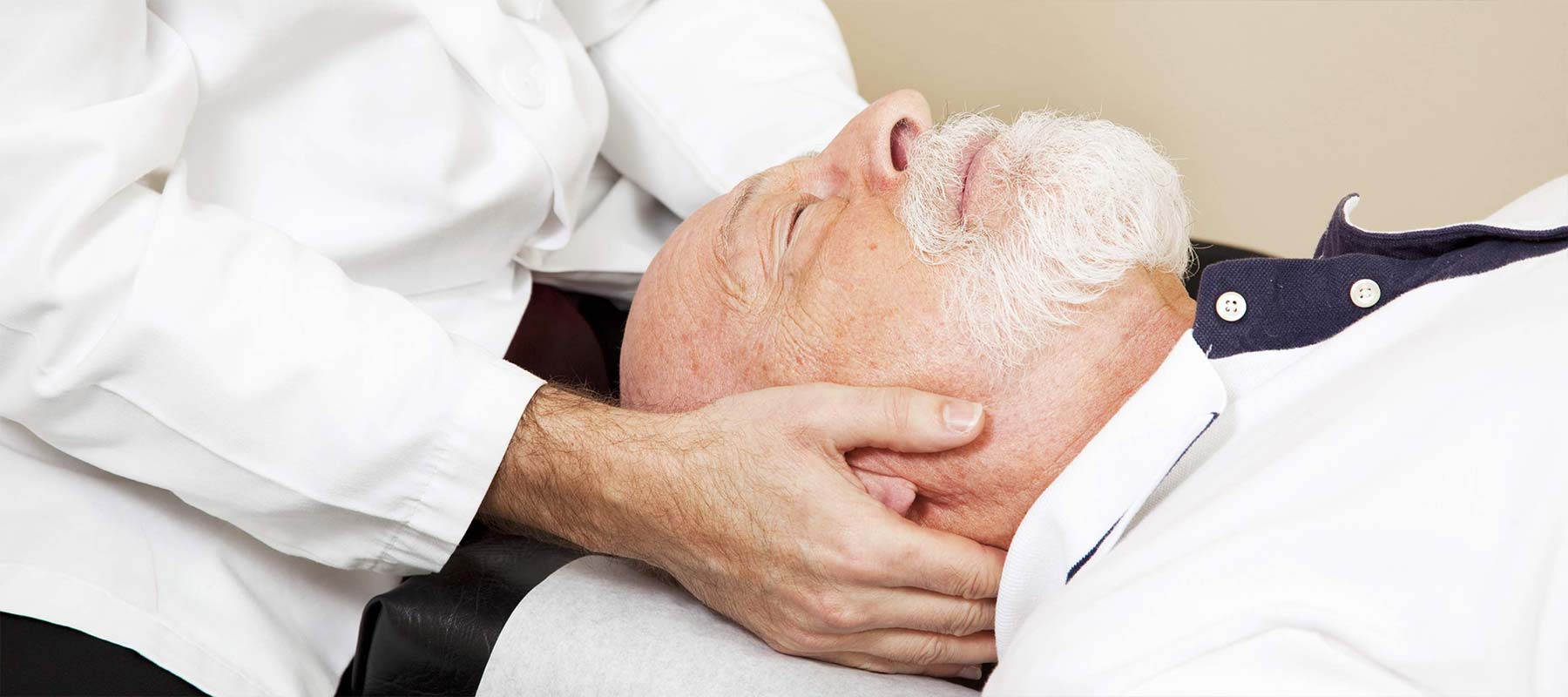 An old man receiving neck treatment